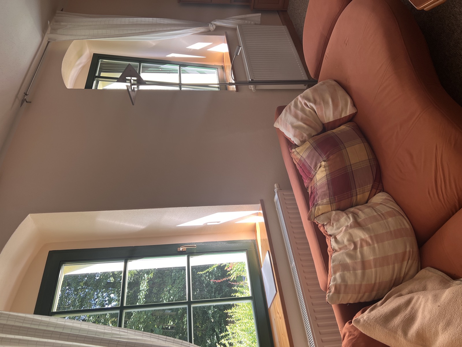Wohnzimmer mit Sofa und Blick in den Wald