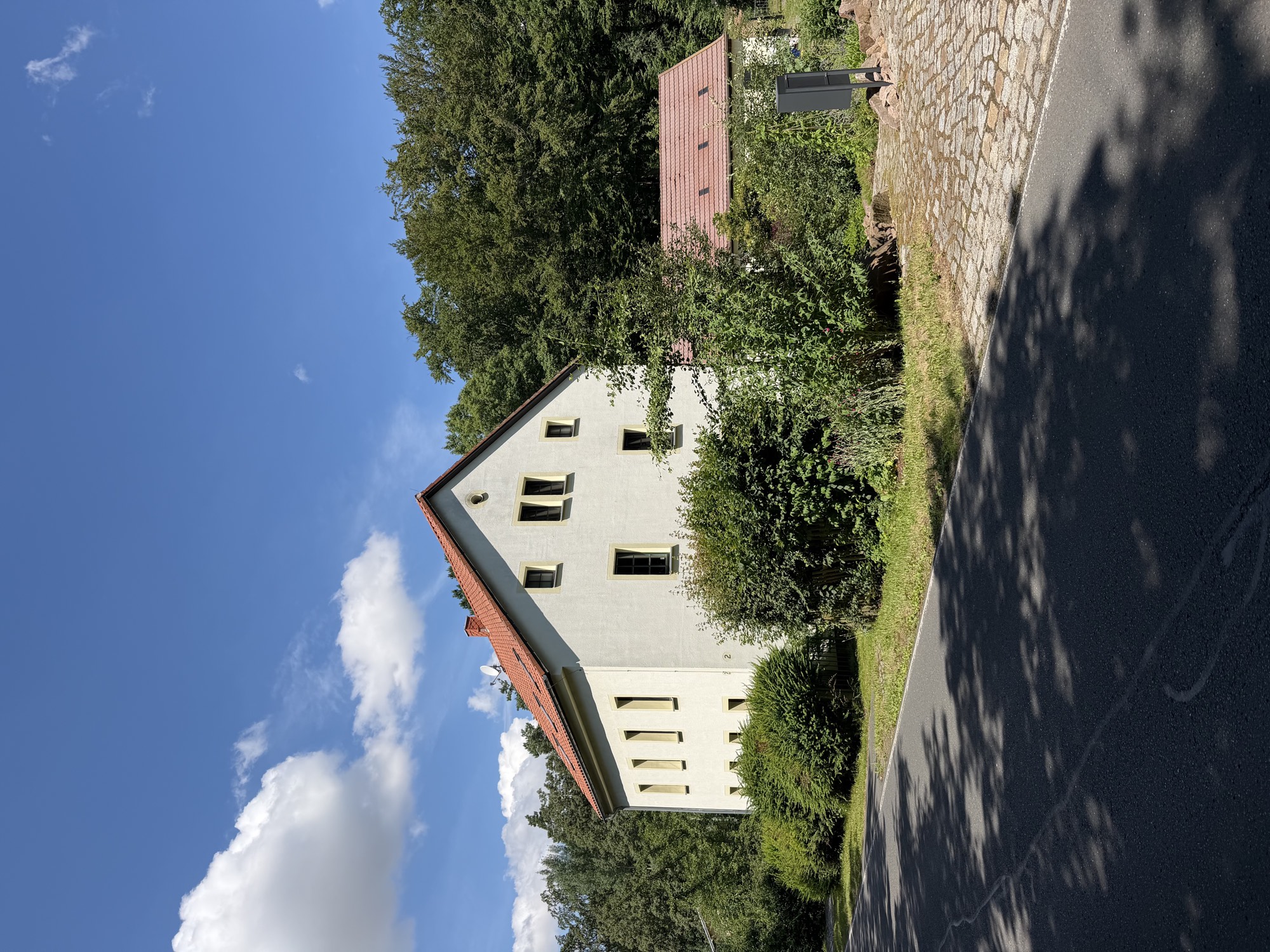 Das Waldhaus Freiberg am Waldrand unter blauem Sommerhimmel